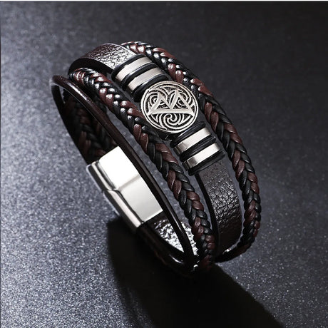 Bracelet with braided design and metal emblem on a dark background