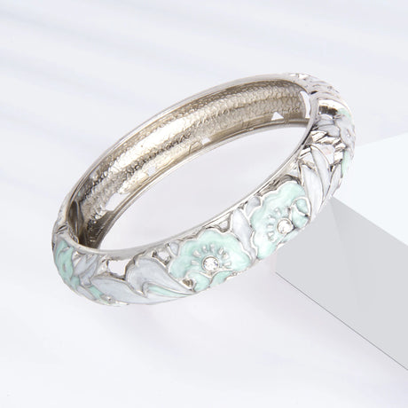 Silver bracelet with floral design on a white background