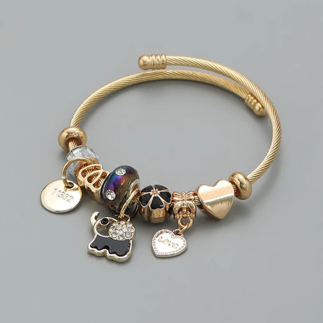 Gold bracelet with various charms on a gray background