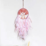 Pink feathered dreamcatcher with tree of life design on a white background