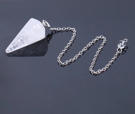 Crystal pendant on a chain against a dark background
