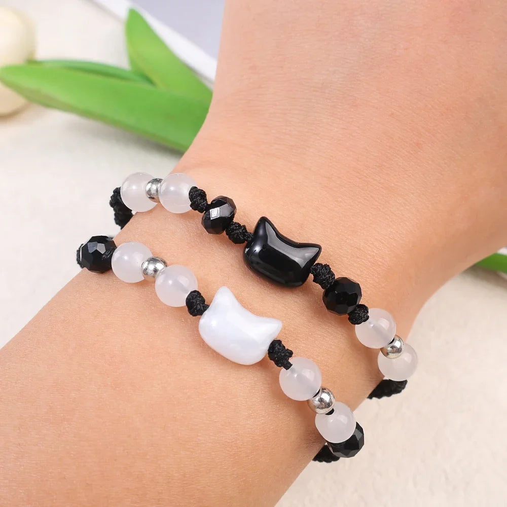 Bracelet with black, white, and silver beads on a wrist against a light background