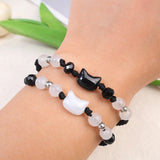 Bracelet with black, white, and silver beads on a wrist against a light background