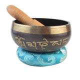 Tibetan singing bowl with a wooden striker on a white background