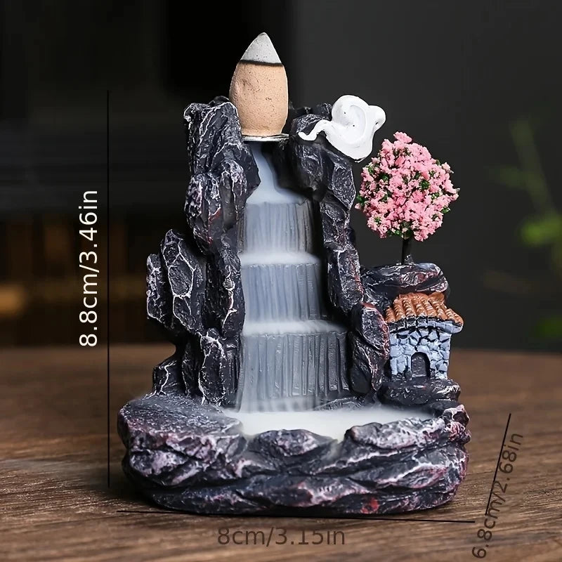 Decorative fountain with rocks, water, and a small house on a wooden surface.