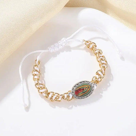 Gold chain bracelet with a circular emblem on a white surface