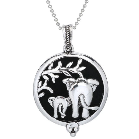 Silver pendant with elephant design on a black background, hanging from a chain.