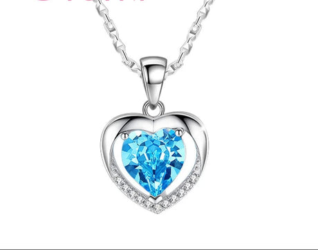 Heart-shaped necklace with blue gem and silver chain on a white background, featuring the brand 'Giemi'.