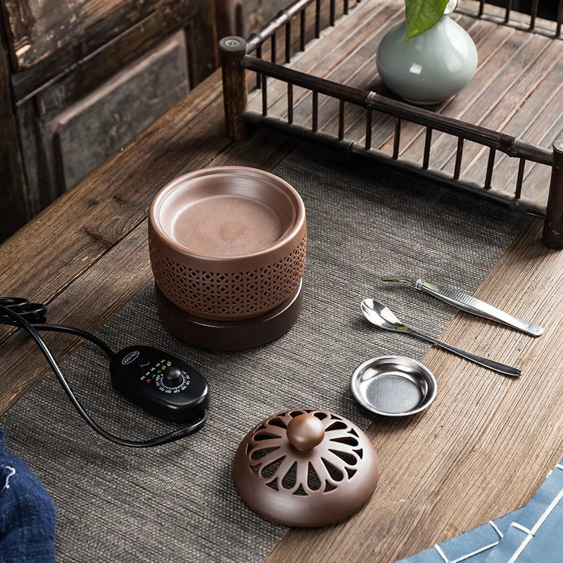 Ceramic incense burner with accessories on a wooden table