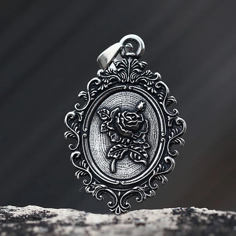Silver pendant with rose design on a dark background