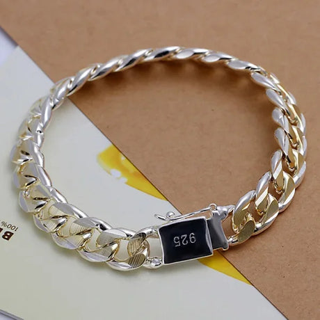 Gold and silver chain bracelet on a beige background