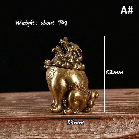 Gold lion statue with measurements on a wooden surface