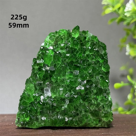 Green crystal rock on a wooden surface with a gray background