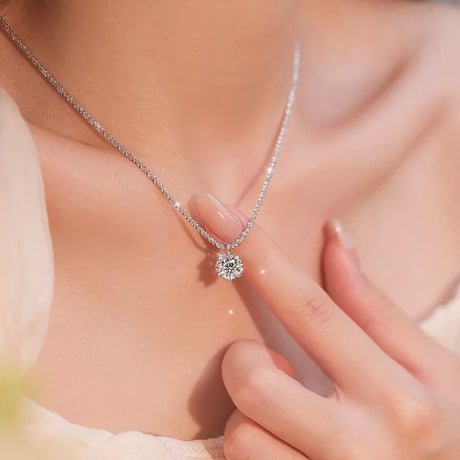 Diamond necklace being worn on a person's neck with a hand adjusting it.