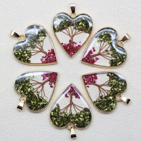 Heart-shaped pendants with green and pink leafy designs on a light gray background