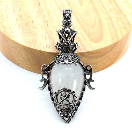 Decorative pendant with a white central stone on a wooden background