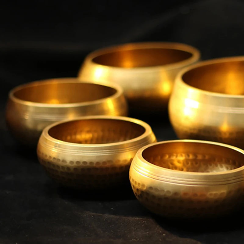 Set of gold singing bowls on a dark background