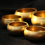 Set of gold singing bowls on a dark background