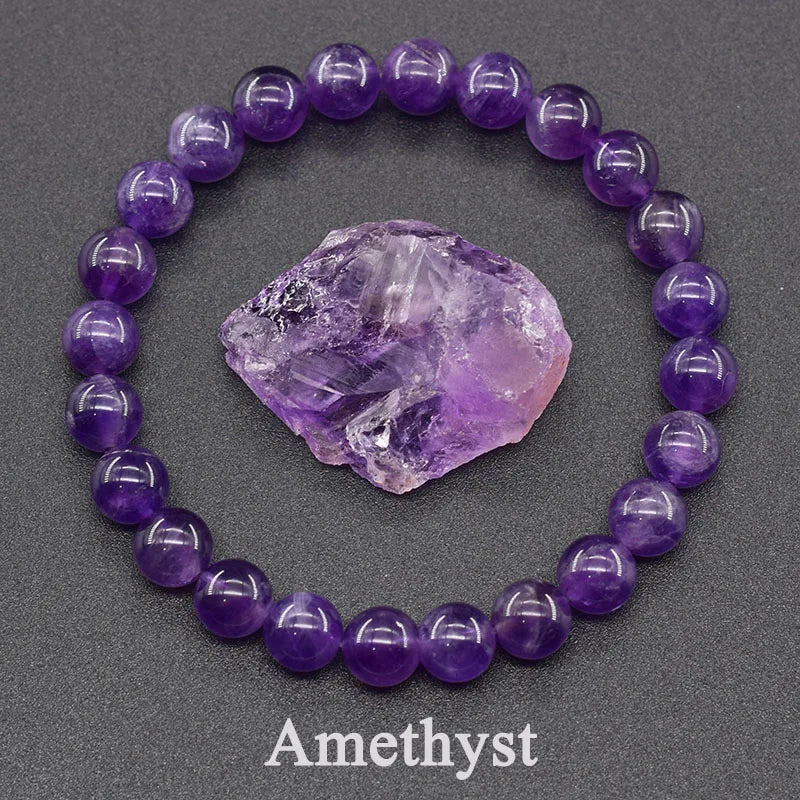 Purple beaded bracelet with a purple crystal on a gray background, featuring the word 'Amethyst'.