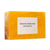 Yellow bar of turmeric & kojic soap with a white label on a white background