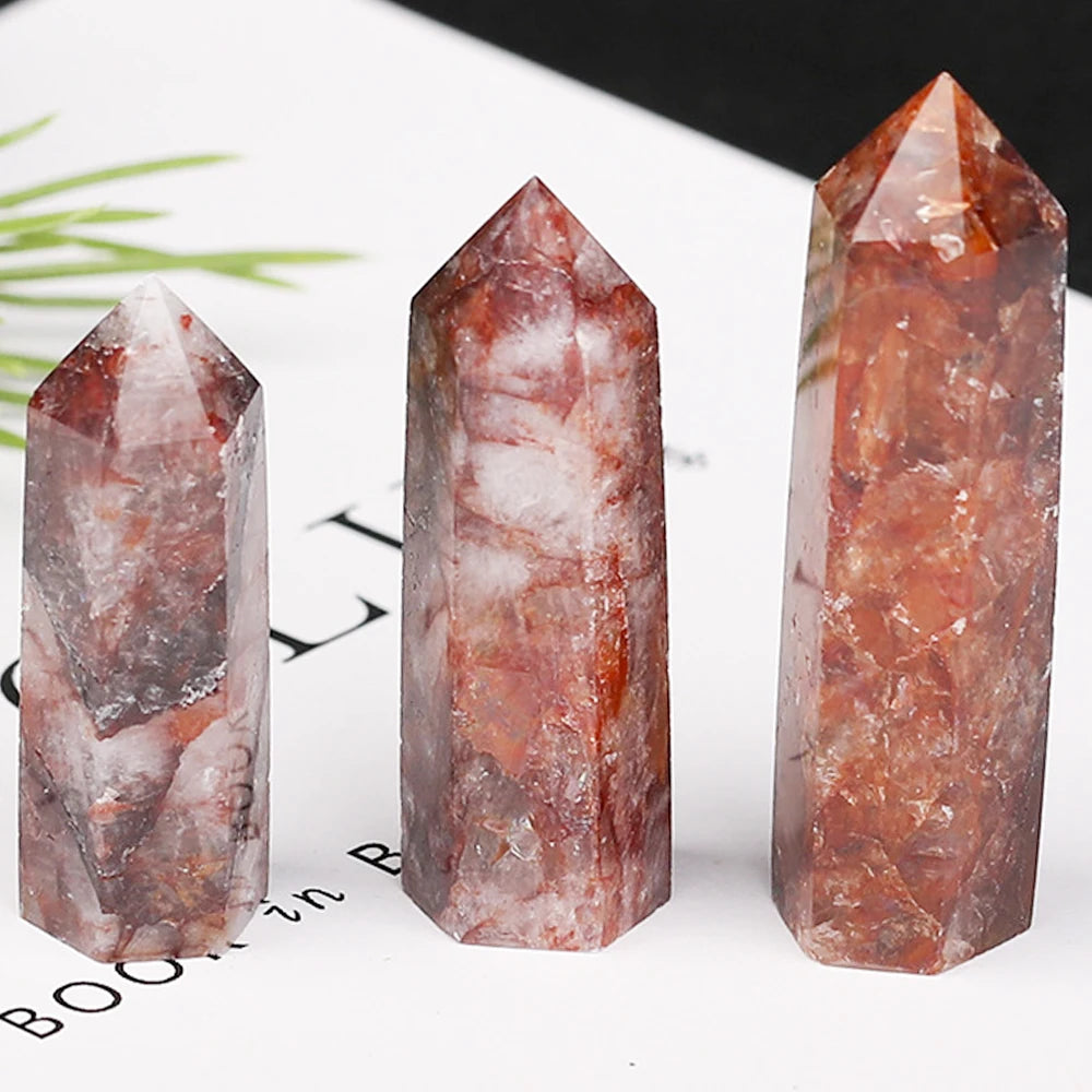 Three crystal towers with red and white patterns on a white surface.