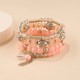 Set of beaded bracelets with gold accents on a beige background