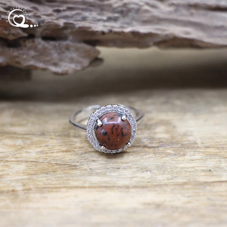 Ring with a red stone and silver band on a wooden surface