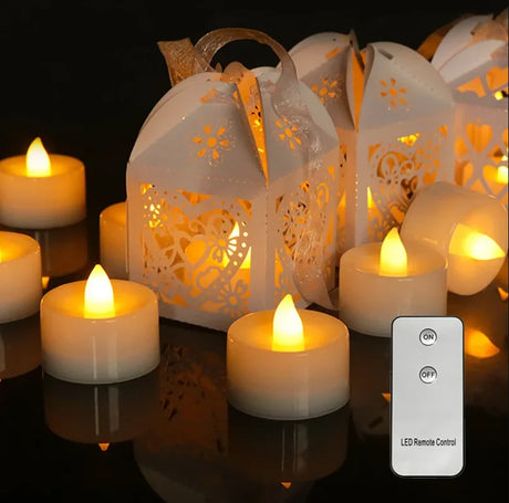 Decorative white lanterns with lit candles and a remote control on a reflective surface.