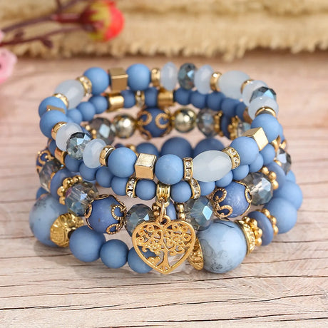 Stack of blue beaded bracelets with gold accents on a wooden surface