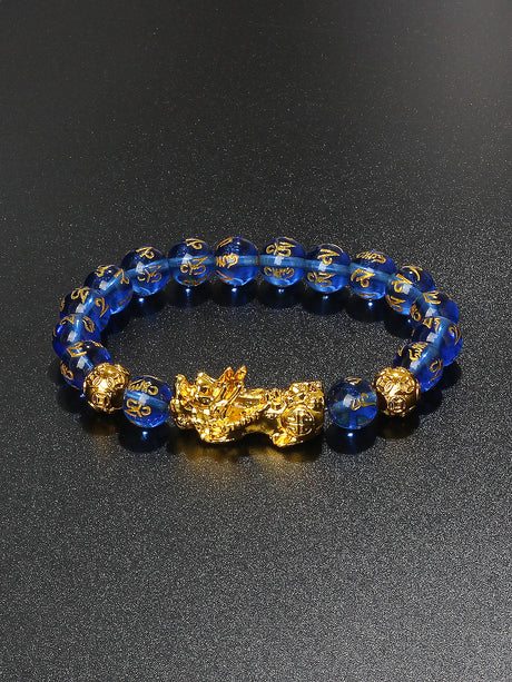 Blue beaded bracelet with gold accents on a black background