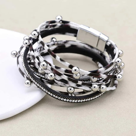 Multi-layered bracelet with beads and metal accents on a light background