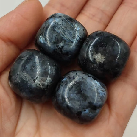 Four dark blue stones held in a hand
