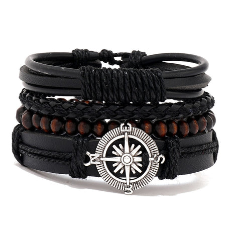 Stack of black leather and wood beaded bracelets with a silver compass charm on a white background