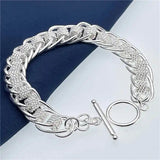 Silver bracelet with intricate design on a blue and white striped background