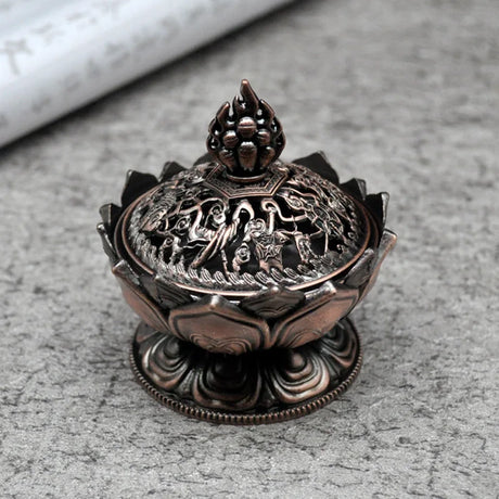 Decorative metal incense burner with intricate designs on a gray surface