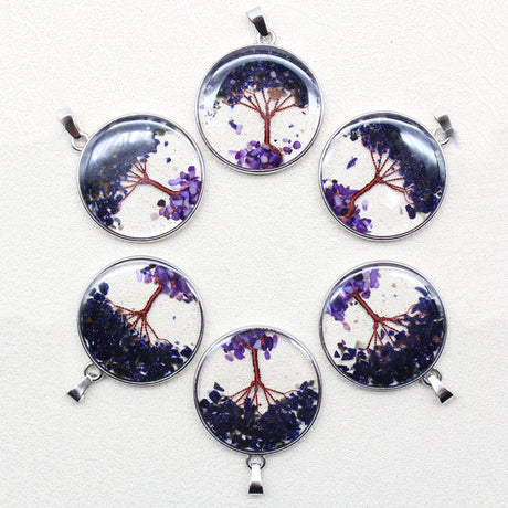 Set of six round pendants with tree designs on a white background