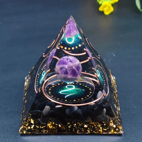 Decorative pyramid with purple crystal ball on a dark background