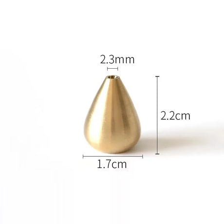 Gold teardrop-shaped object with measurements on a white background