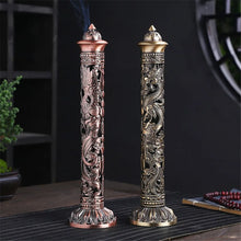 Two intricately designed incense sticks on a dark surface with a blurred background