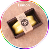 Yellow soap bar in a brown box with 'Lemon' text on a textured beige background
