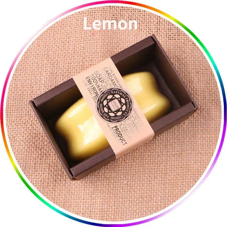 Yellow soap bar in a brown box with 'Lemon' text on a textured beige background