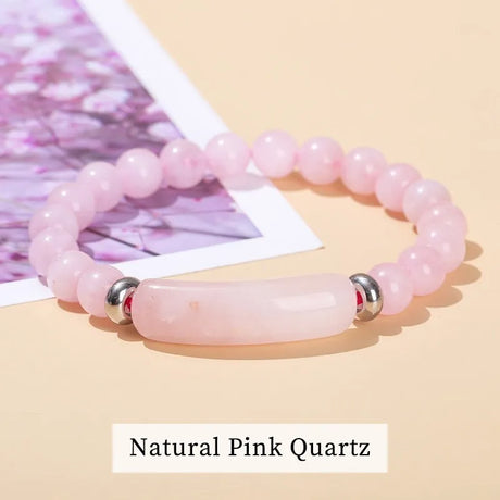 Pink quartz bracelet with silver accents on a beige background