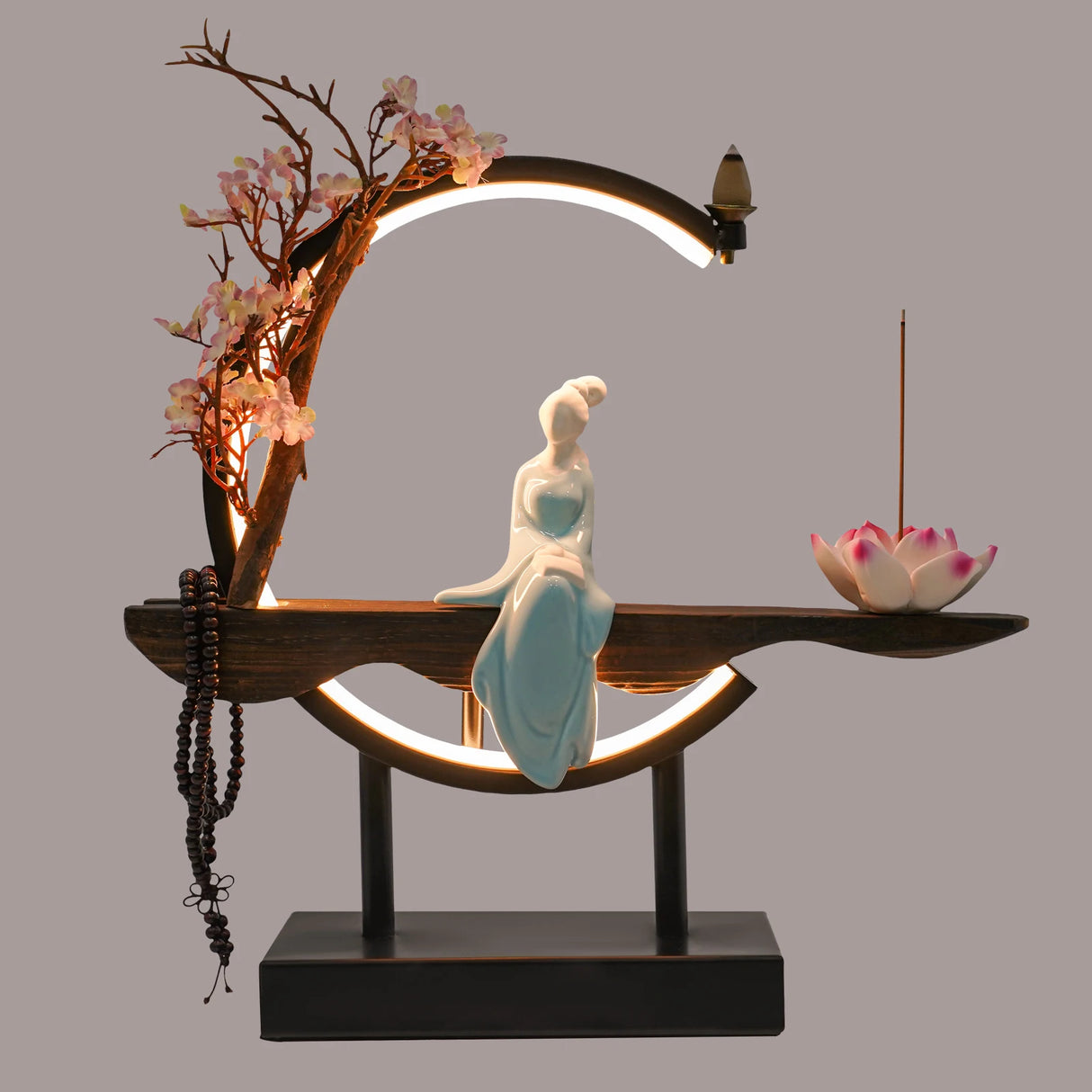 Decorative scene with a figurine, incense, and cherry blossoms on a gray background