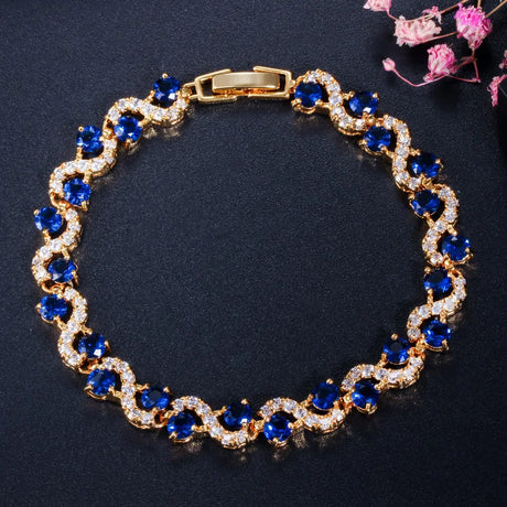 Gold bracelet with blue gemstones on a dark background