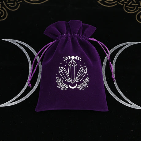 Purple drawstring bag with crystal design on a black background with moon symbols.