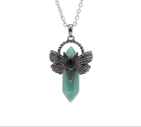 Necklace with butterfly pendant and green stone on a white background