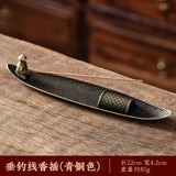 Bronze incense holder with incense sticks on a wooden surface