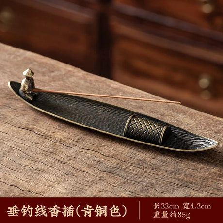 Bronze incense holder with incense sticks on a wooden surface