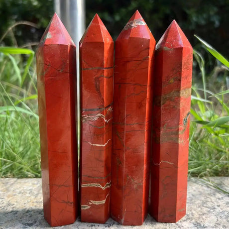 Four red marbled crystal points on a natural background
