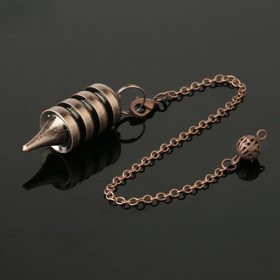 Bronze-colored metal object with chain on a black background